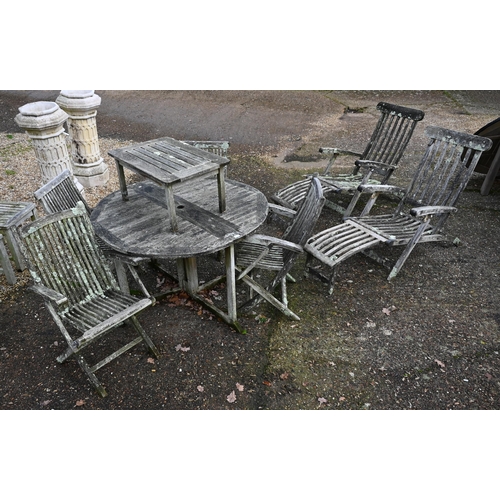 3 - A heavily weathered teak circular garden table and set of four armchairs to/w a pair of teak steamer... 