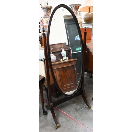 361 - An oval cheval mirror with mahogany frame and stand with tapering columns and splayed legs with bras... 