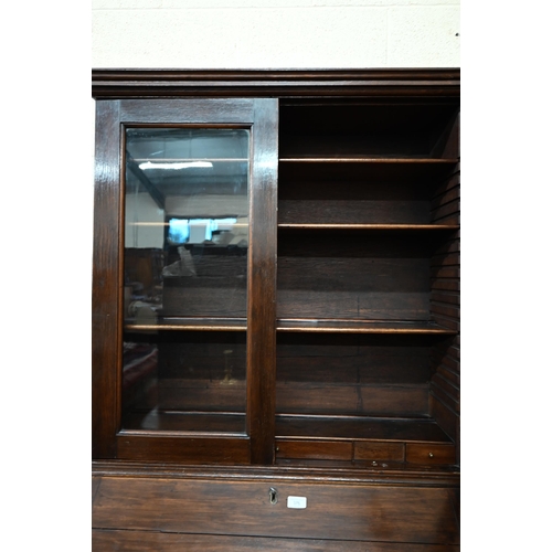 376 - #A German oak bureau bookcase with glazed doors over a fall-front panel enclosing fitted interior an... 