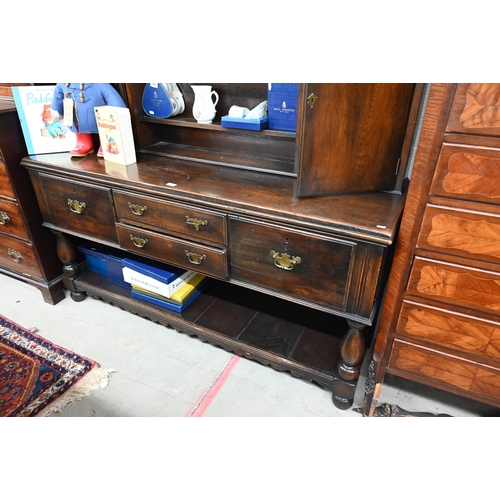 383 - A Georgian style oak dresser, the raised back with open shelves and cupboards on the base with four ... 