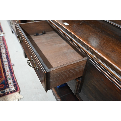 383 - A Georgian style oak dresser, the raised back with open shelves and cupboards on the base with four ... 