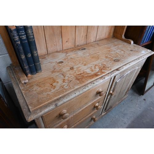 387 - A stripped pine kitchen dresser with two-shelf plate rack on a base with three drawers and panelled ... 