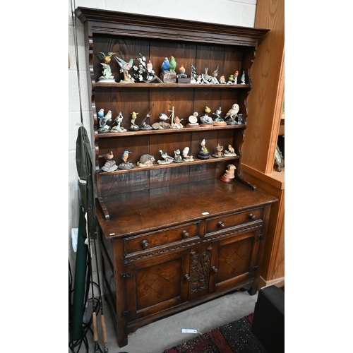 391 - A small early 20th century carved oak dresser, the shallow plate rack with three shelves on a base w... 