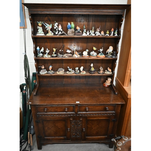 391 - A small early 20th century carved oak dresser, the shallow plate rack with three shelves on a base w... 