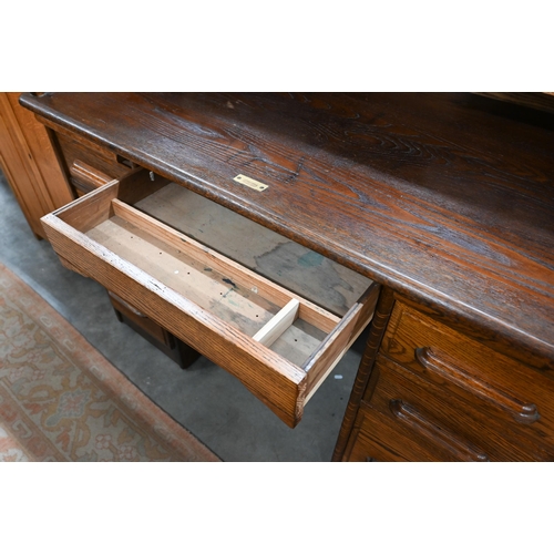 407 - An early 20th century oak roll-top desk, the sliding tambour panel enclosing a fitted interior, over... 