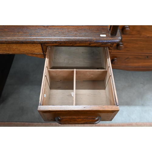 407 - An early 20th century oak roll-top desk, the sliding tambour panel enclosing a fitted interior, over... 