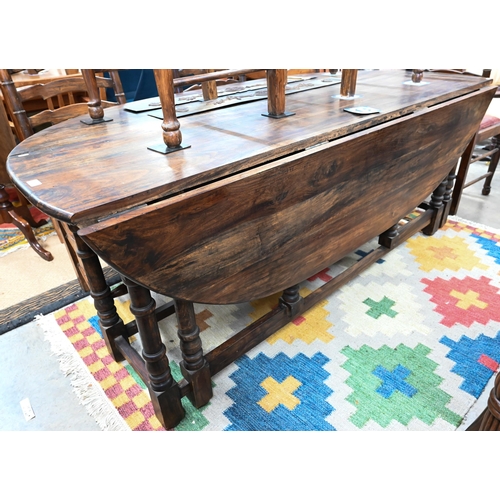 433 - A substantial reproduction hardwood wake/dining table with two drawers raised on turned gate-leg act... 