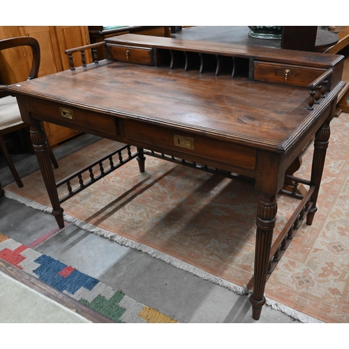 434 - A reproduction stained hardwood writing table with galleried top, turned and reeded supports united ... 