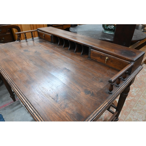 434 - A reproduction stained hardwood writing table with galleried top, turned and reeded supports united ... 