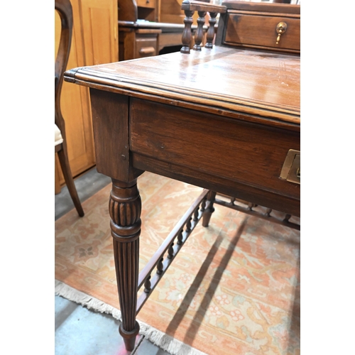 434 - A reproduction stained hardwood writing table with galleried top, turned and reeded supports united ... 