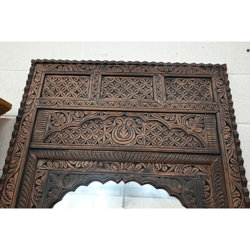 445 - An Indian stained and foliate carved teak window mirror, 84 cm wide x 108 cm high