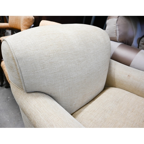 446 - A Highly Sprung Howard-style armchair in buttermilk chenille upholstery on tapering hardwood support... 