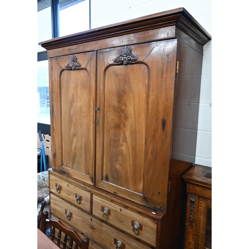 460 - A 19th century mahogany linen press with panelled doors enclosing slides over two short and two long... 