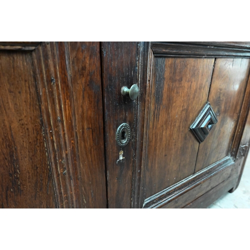 471 - An antique oak cabinet, the cleated planked top over pair of panelled cupboard doors a/f, 152 cm wid... 