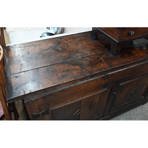 471 - An antique oak cabinet, the cleated planked top over pair of panelled cupboard doors a/f, 152 cm wid... 