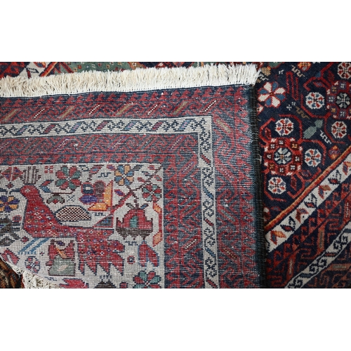 49 - A vintage Persian Hamadan rug, the geometric medallion designs on dark blue ground within repeating ... 