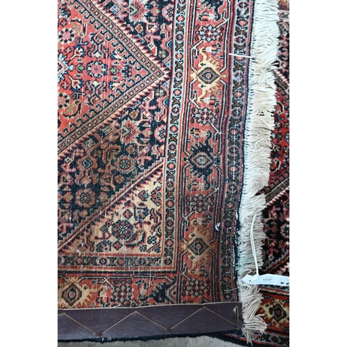 495 - A Persian Bidjar rug, intricate floral design on red/blue ground with guarded conforming borders