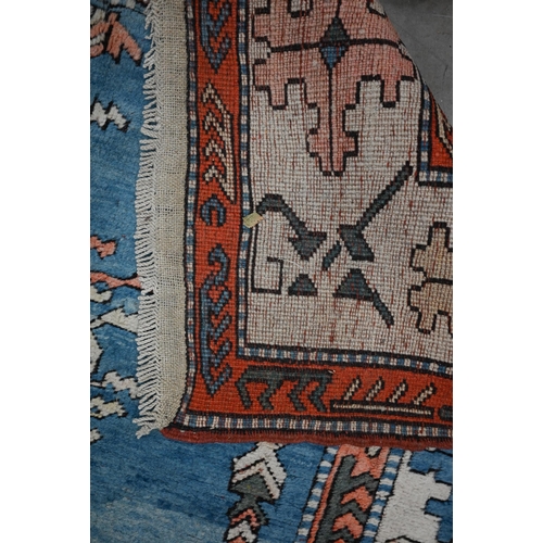 498 - A Turkish Milas rug, abrashed sky-blue ground with symmetrical tree design with geometric cream bord... 