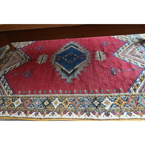 499 - Turkish carpet geometric design with blue diamond medallion on red ground, cream and mustard repeati... 