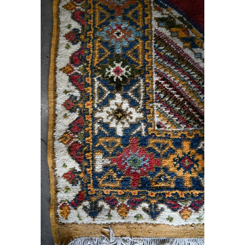 499 - Turkish carpet geometric design with blue diamond medallion on red ground, cream and mustard repeati... 