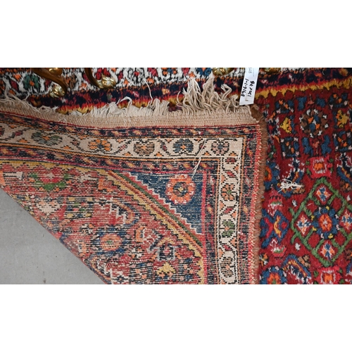 548 - A pair of Persian Hamadan rugs, each with all-over rosettes/floral designs on red ground, blue and c... 