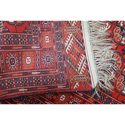 564 - Persian Turkoman rug, repeating gul design on red ground, multi borders, 150 x 100 cm