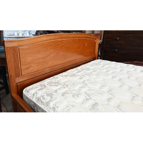 572 - A cherrywood queen size double bed with panelled headboard and reeded detailing c/w hinged storage-b... 