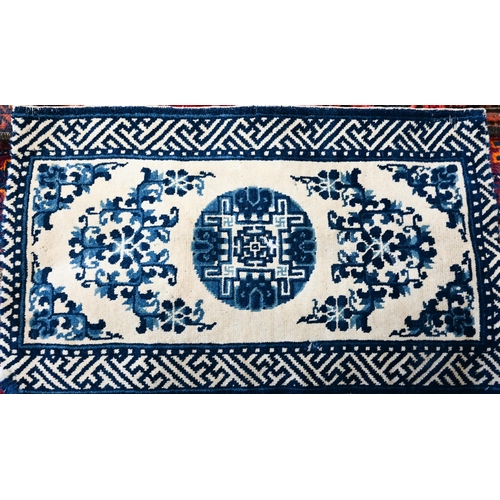 573 - A Chinese blue and white small Peking rug of typical design, 89 x 52 cm to/w a Moroccan red ground r... 