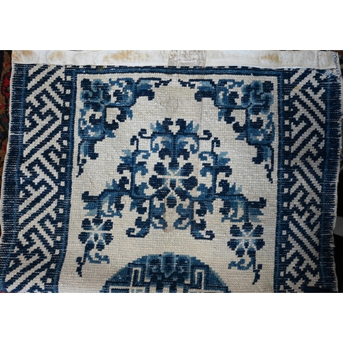 573 - A Chinese blue and white small Peking rug of typical design, 89 x 52 cm to/w a Moroccan red ground r... 