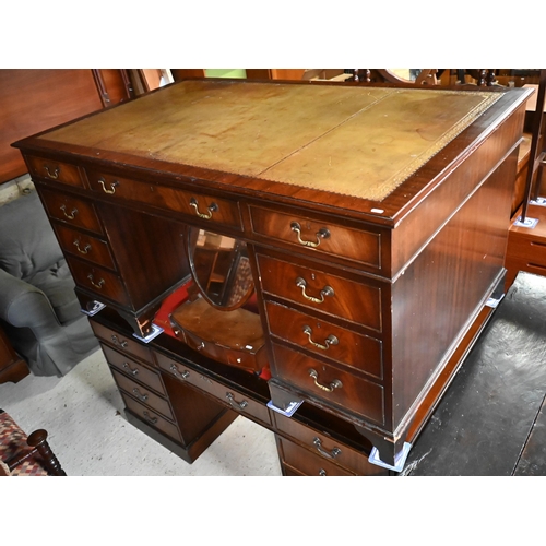 603 - A large twin pedestal mahogany desk with pale  green leather top over an arrangement of nine dr... 