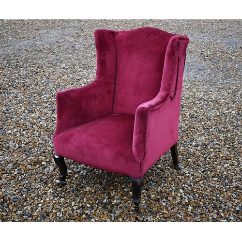 621 - An Edwardian wingback armchair in burgundy dralon upholstery (A/F)