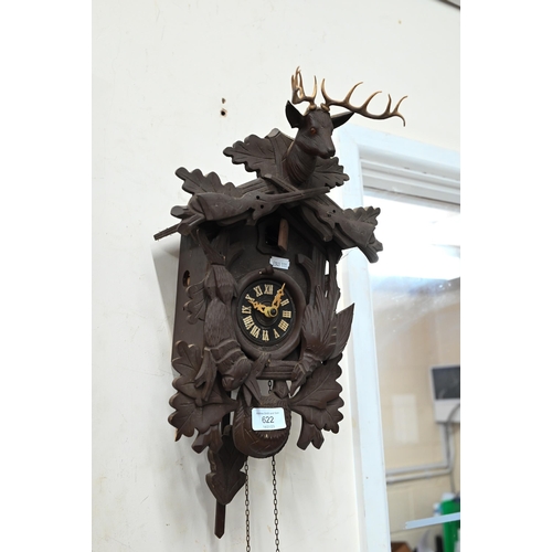 622 - A West German Black Forest style small cuckoo clock (A/F) carved with animals and surmounted by the ... 