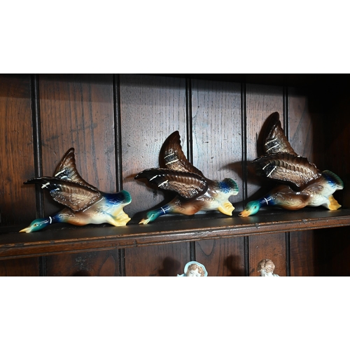 64 - Graduated set of three Jena (Holland) pottery flying ducks, 24-16 cm (chip on wing of largest), to/w... 