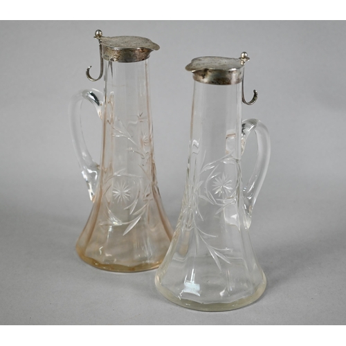 115 - Matched pair of Edwardian cut glass claret jugs with flared bases and silver collars and covers with... 