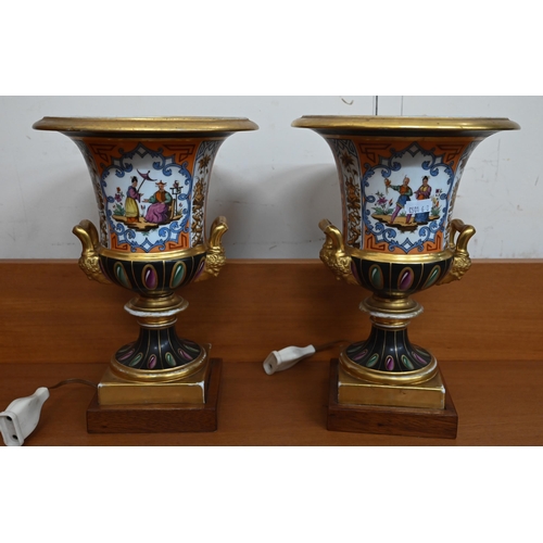 57 - Pair of Paris porcelain urns, the reserves painted with mandarins, 26 cm high, on later wooden plint... 