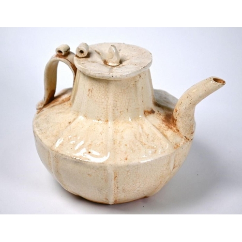 529 - A Chinese Northern Song style teapot and cover with crackled cream-glaze and relief decoration, post... 