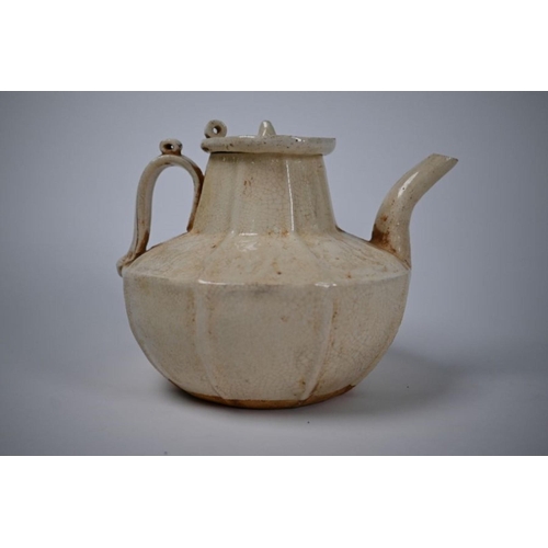529 - A Chinese Northern Song style teapot and cover with crackled cream-glaze and relief decoration, post... 