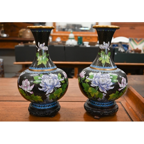199 - Pair of Chinese cloisonné vases with floral decoration on a black ground, on carved wood bases, 28 c... 
