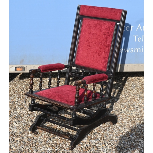 437 - An early 20th century American rocking chair with turned frame, red fabric upholstery
