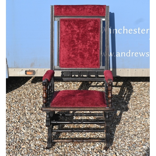 437 - An early 20th century American rocking chair with turned frame, red fabric upholstery