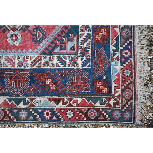 448 - A Turkish kelleigh carpet, geometric design with diamond medallions on red ground with blue border, ... 