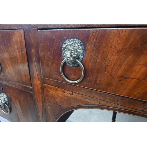 454 - A Regency mahogany sideboard with four drawers and brass lion mask ring handles raised on tapering s... 