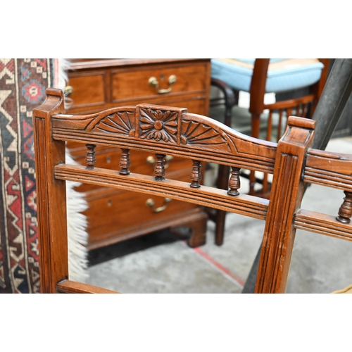 467 - # An Edwardian child's carved beech double chair-back settee with padded arms and seat, on turned su... 