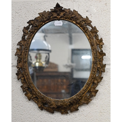 485 - A small antique ovall wall mirror in floral and foliate giltwood and gesso frame, 34 cm high x 28 cm... 