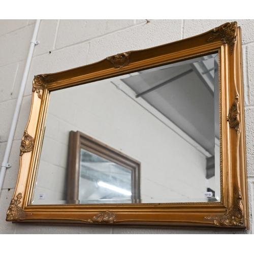 504 - A bevelled wall mirror in decorative moulded gilt frame, 90 cm wide x 64 cm high