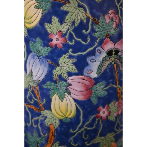 95 - Chinese porcelain cylindrical stick stand with polychrome enamel melons and moths on a blue ground, ... 