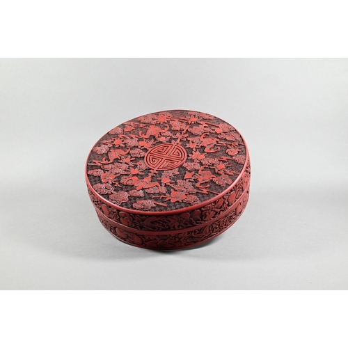551 - A large Chinese cinnabar style circular box and cover, profusely carved with arrangements of bats, c... 