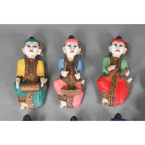 554 - A set of seven vintage polychrome Burmese temple musician wall plaques, carved hardwood with gilded ... 