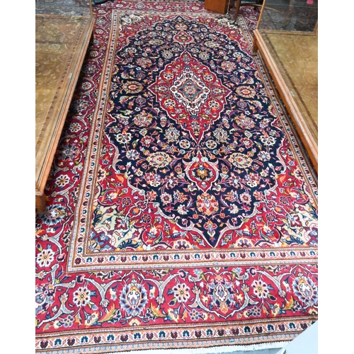 1050 - A contemporary central Persian Kashan carpet, the blue and red ground centred by a floral medallion,... 