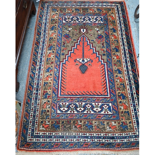 1052 - A contemporary Turkish prayer design rug, the coral ground centre panel flanked by stylised floral d... 